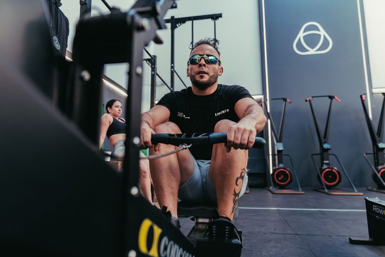 A man focused on rowing exercise in a modern gym in Pereira, Colombia.